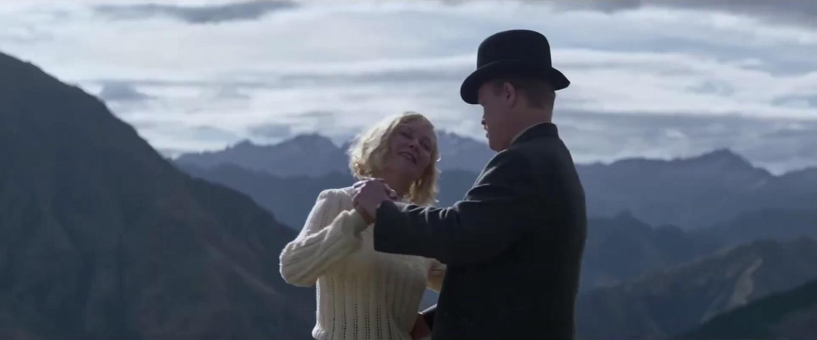 a man and a woman standing on top of a mountain
