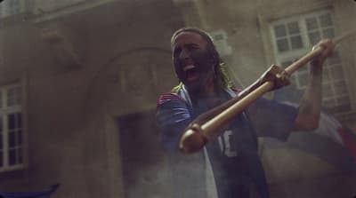 a man holding a baseball bat in front of a building