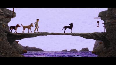 a man walking across a bridge with three dogs