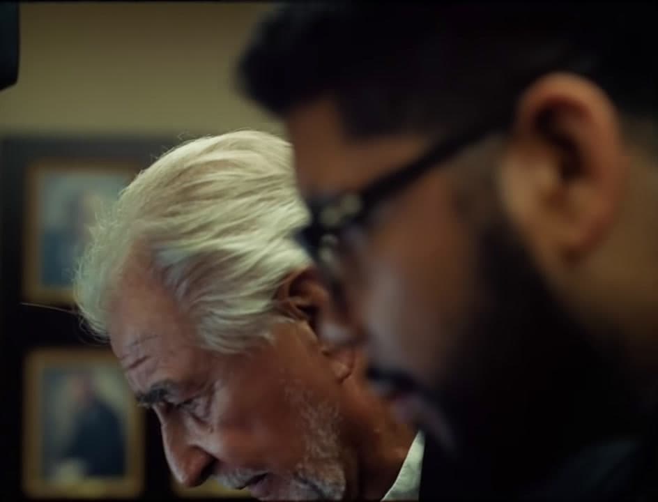 two men looking at something in a mirror