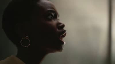 a woman with her mouth open in a dark room