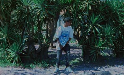 a man standing in front of a bunch of palm trees
