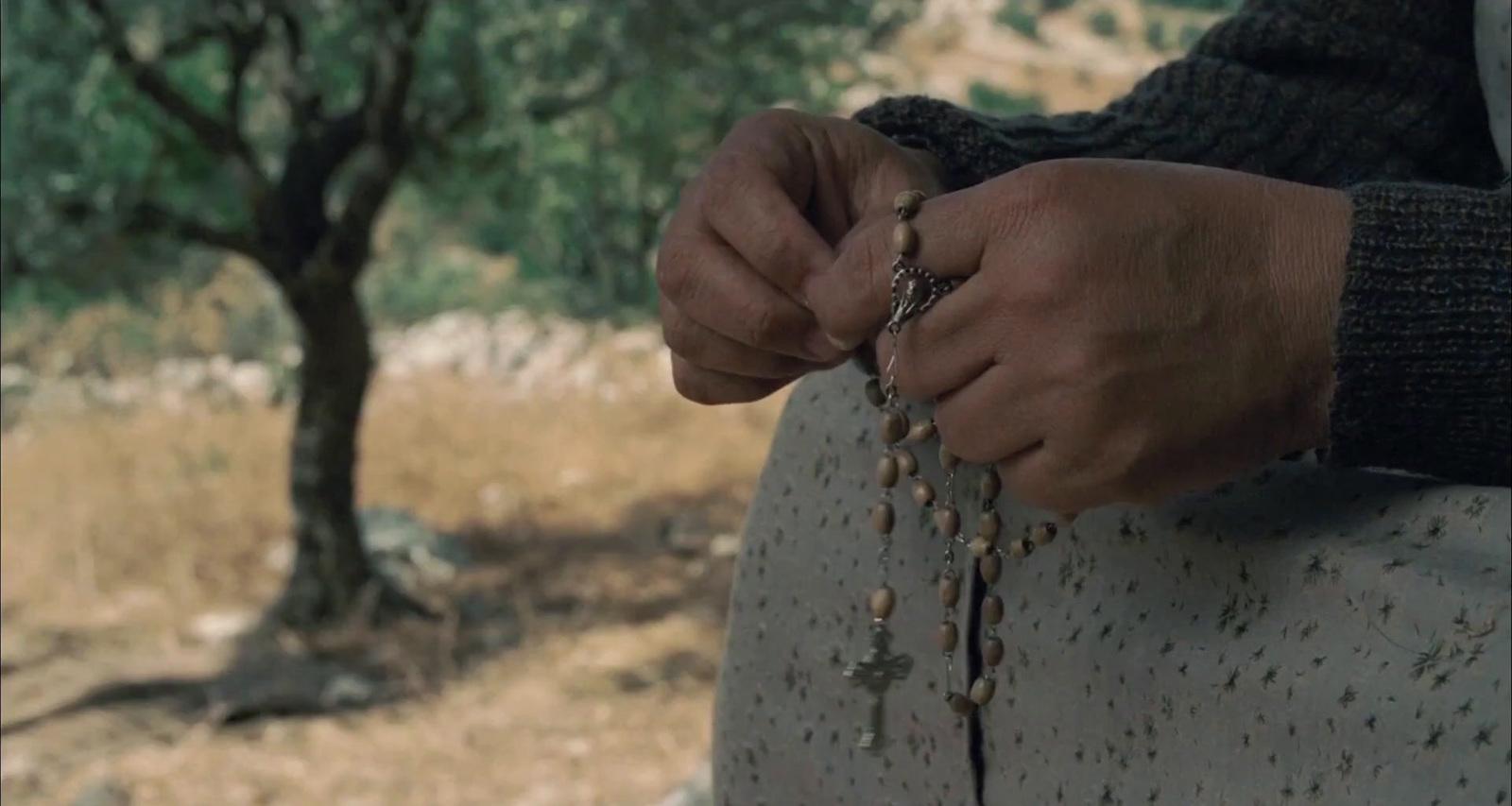 a person holding a rosary in their hands