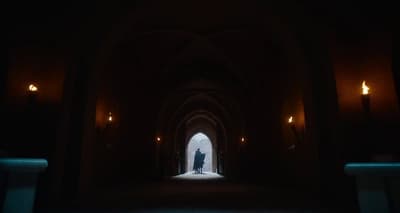 a person standing in a dark tunnel with a light at the end