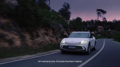 a white car driving down a curvy road