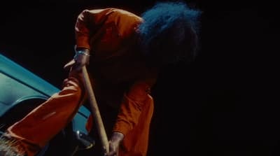 a man with blue hair holding a wooden stick