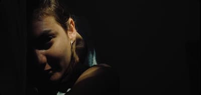 a woman with her eyes closed in the dark