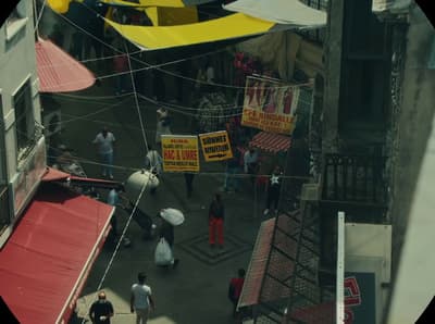 a group of people walking down a street next to buildings