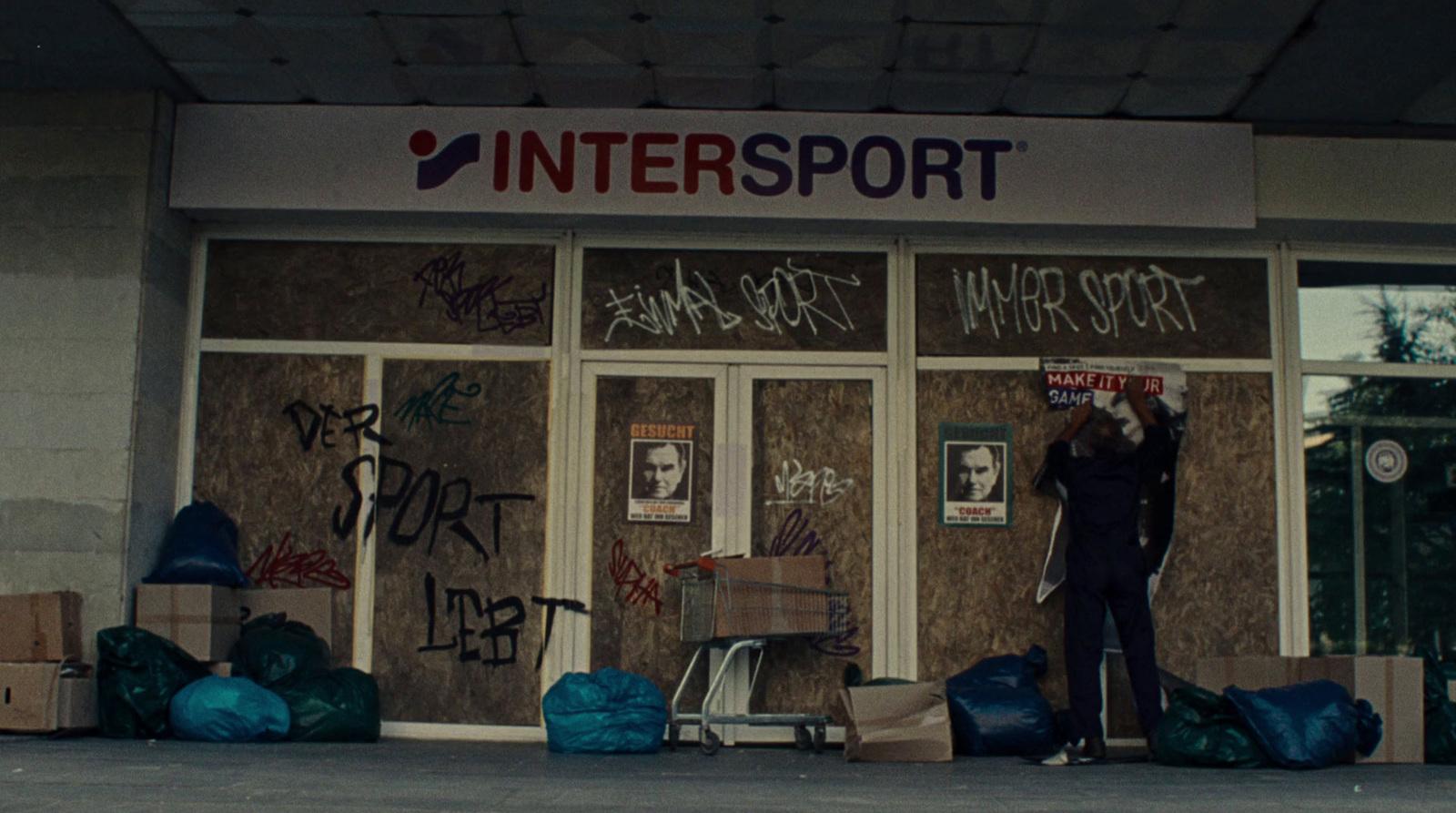 a man standing in front of a building covered in graffiti