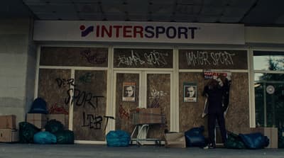 a man standing in front of a building covered in graffiti