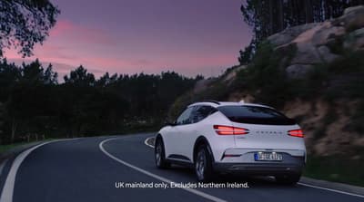 a white car driving down a curvy road