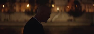 a man in a suit and tie standing in front of a building