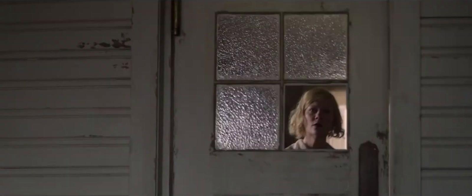 a woman looking out of a window of a house