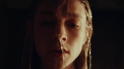 a woman with long hair and water dripping from her mouth