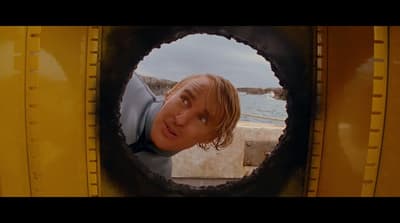 a man looking through a hole in a yellow truck