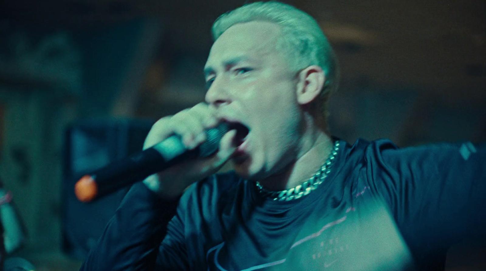 a man in a black shirt singing into a microphone