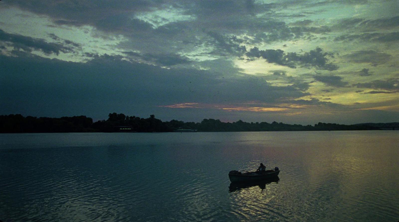 a person in a small boat on a large body of water