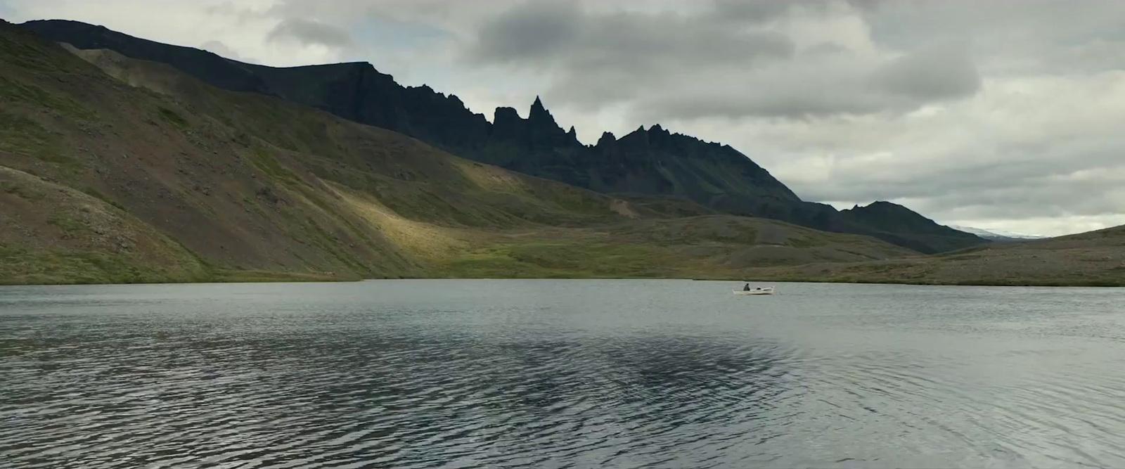 a body of water with mountains in the background