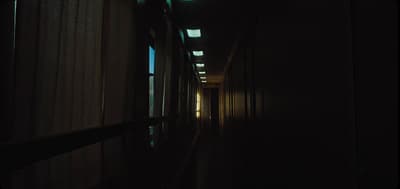 a long dark hallway with light coming through the windows