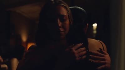 a woman holding a man in a dark room