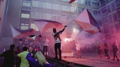 a man standing on top of a stage holding a flag