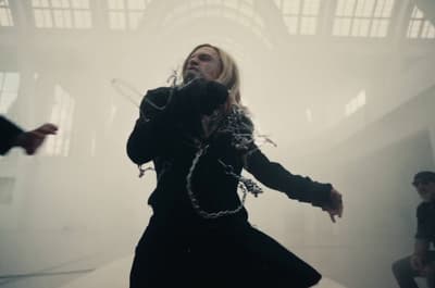 a man in a black jacket and chains on his hands
