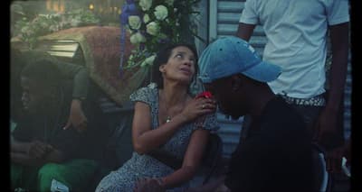 a woman sitting next to a man on a bench