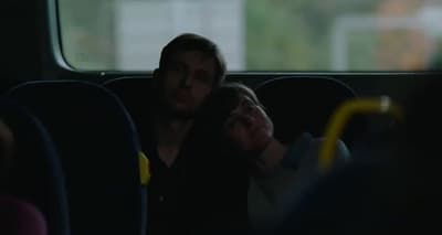 a man sitting on a bus holding a cell phone
