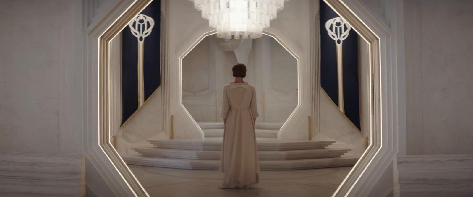 a woman in a long dress standing in a room