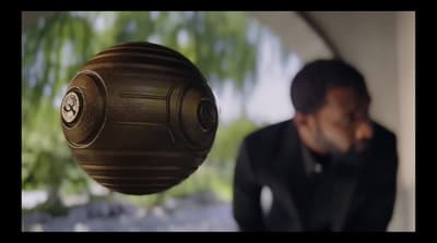 a man standing next to a large brown object