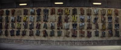 a wall with many pairs of shoes hanging on it