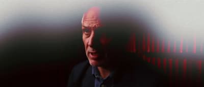 a man in a dark room with a red light