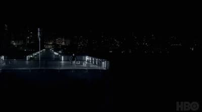 a night time view of a pier and city lights