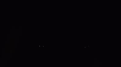 a black and white photo of a clock in the dark