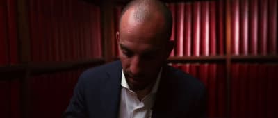 a man with a bald head in a dark room