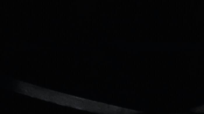 a black and white photo of a knife in the dark