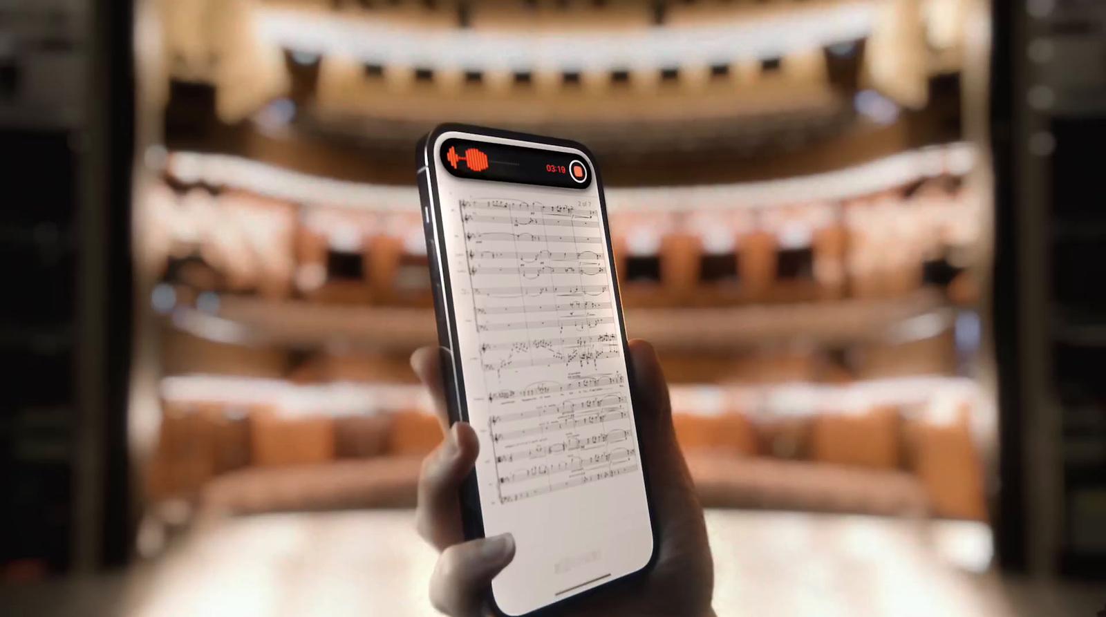 a person holding a cell phone in front of a stage