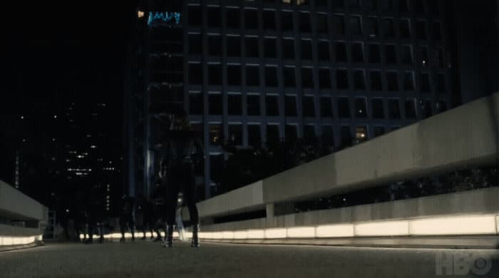 a group of people walking down a street at night