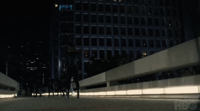 a group of people walking down a street at night