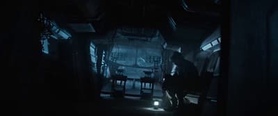 a dark room with a person sitting on a bench