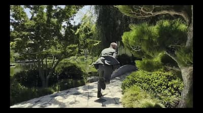 a man walking down a path in a park