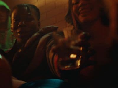 a group of people sitting next to each other holding wine glasses