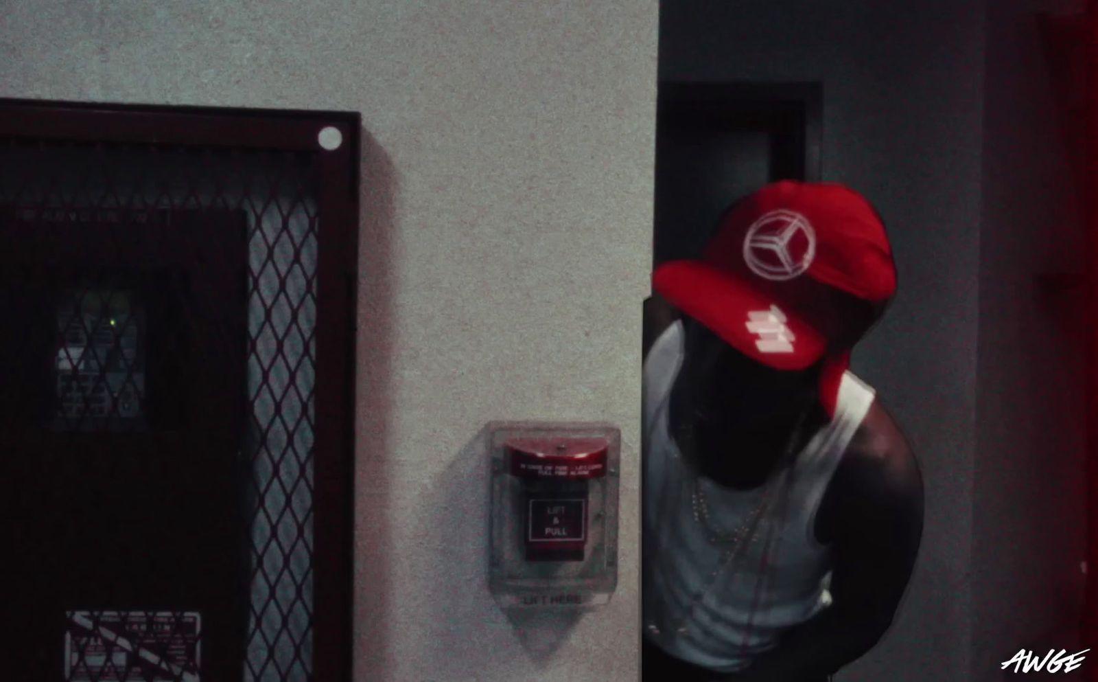 a man wearing a red hat standing next to a wall