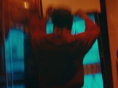 a blurry image of a man standing in front of a tv