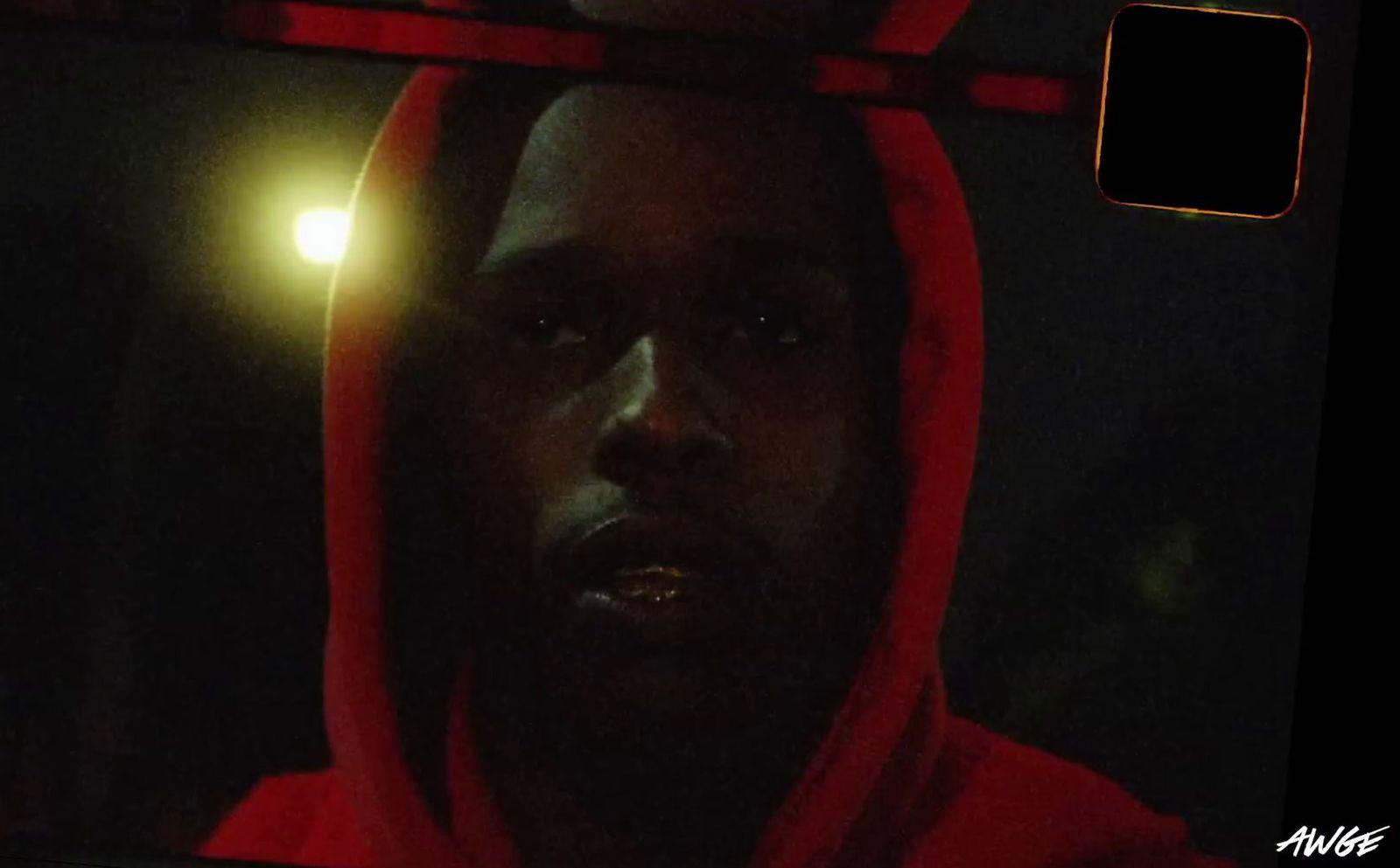 a man in a red hoodie looking at his reflection in a mirror