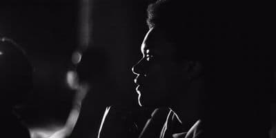 a black and white photo of a man in a dark room