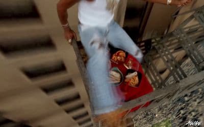 a man in white shirt and jeans holding a plate of food