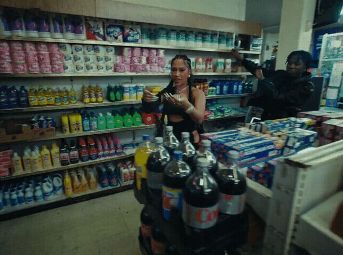 a woman standing in front of a store filled with drinks