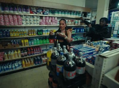 a woman standing in front of a store filled with drinks