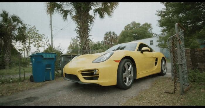 a yellow sports car parked on the side of a road